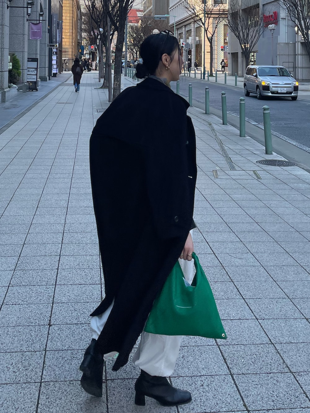 ブルー系のTシャツ/カットソー、グレー系のニット/セーター、グリーン系のショルダーバッグを着用したレディースの春コーディネートの3枚目の写真