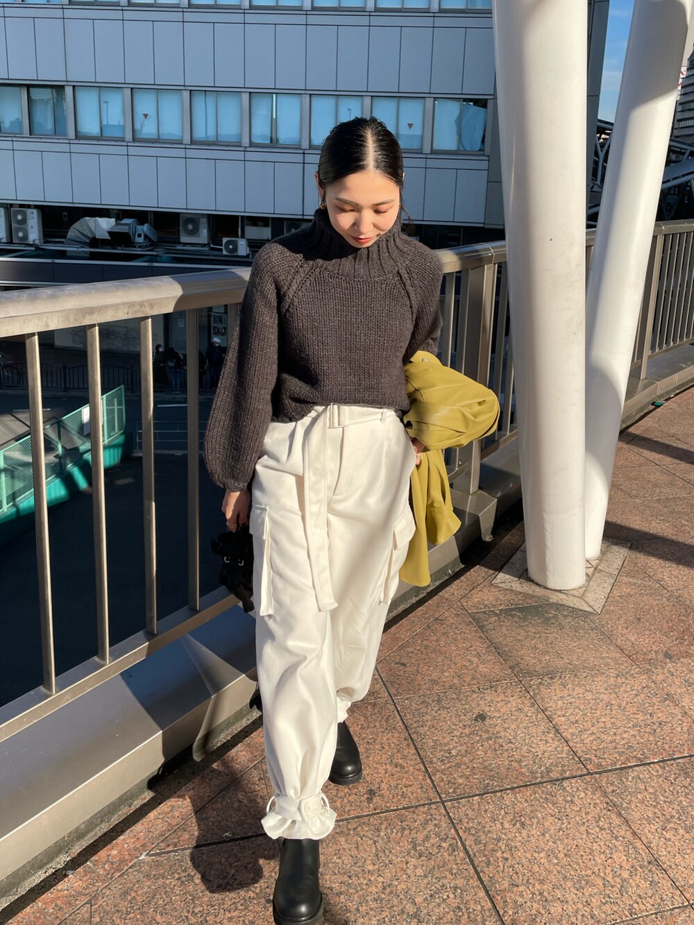 ブラック系のショルダーバッグ、ブラック系のブーツ、ホワイト系のカーゴパンツを着用したレディースの秋コーディネートの4枚目の写真