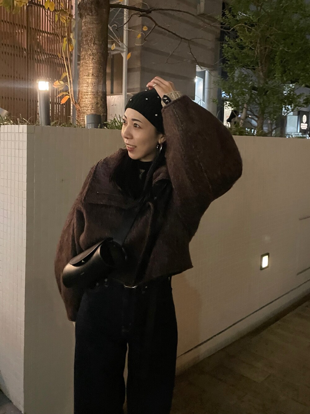 ブルー系のデニムパンツ、ブラウン系のその他アウター、ホワイト系のニット/セーターを着用したレディースの冬コーディネートの5枚目の写真