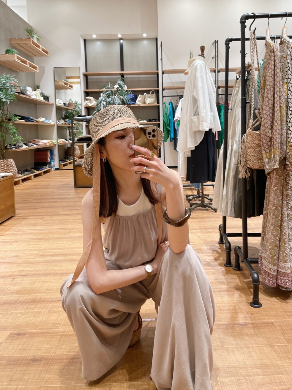 ベージュ系のオールインワン・サロペット、ブラウン系のその他シューズ、ベージュ系のハットを着用したレディースの春コーディネートの2枚目の写真