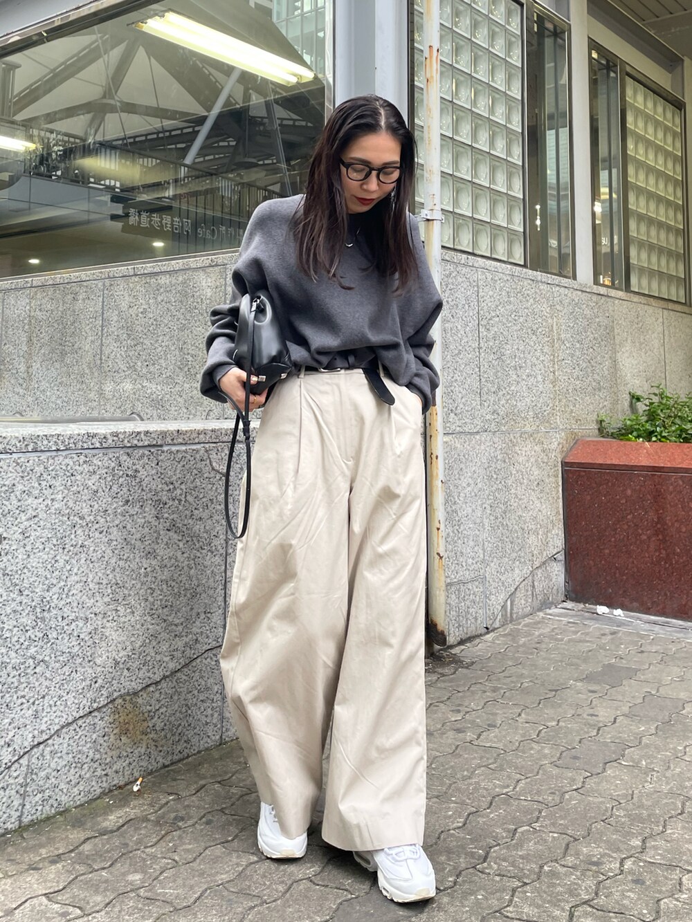 ホワイト系のその他パンツ、グレー系のニット/セーター、ブラック系のショルダーバッグを着用したレディースの冬コーディネートの2枚目の写真