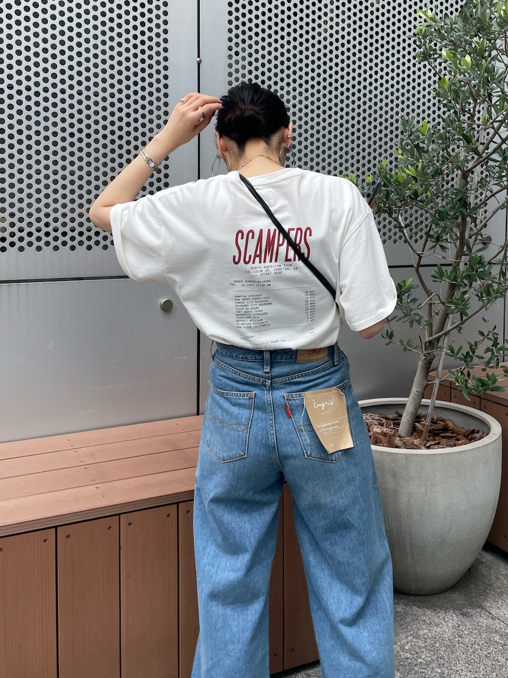 ブルー系のデニムパンツ、ホワイト系のTシャツ/カットソー、グレー系のサンダルを着用したレディースの夏コーディネートの3枚目の写真