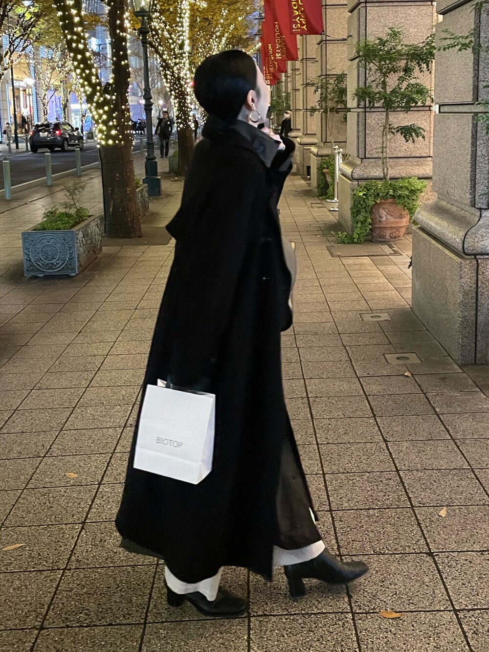 ブラック系のブーツ、ブラック系のチェスターコート、ブラック系のショルダーバッグを着用したレディースの冬コーディネートの4枚目の写真