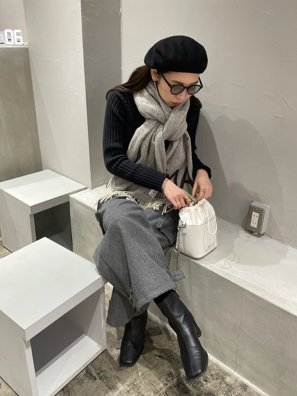 ホワイト系のショルダーバッグ、グレー系のカーゴパンツ、ブラック系のブーツを着用したレディースの冬コーディネートの5枚目の写真