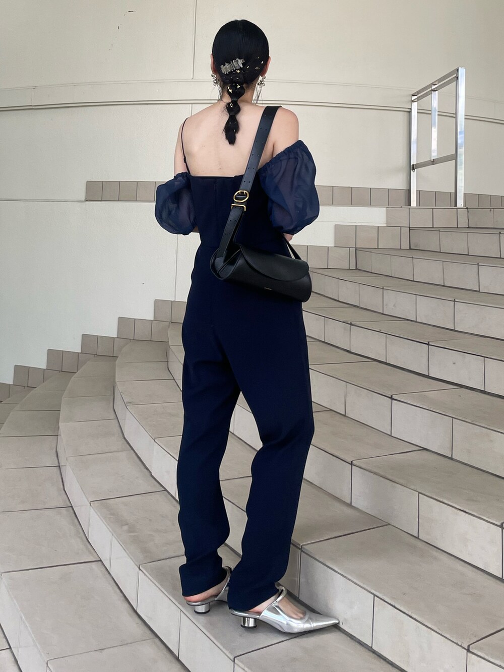 シルバー系のパンプス、ブルー系のドレス、ブラック系のショルダーバッグを着用したレディースの夏コーディネートの4枚目の写真