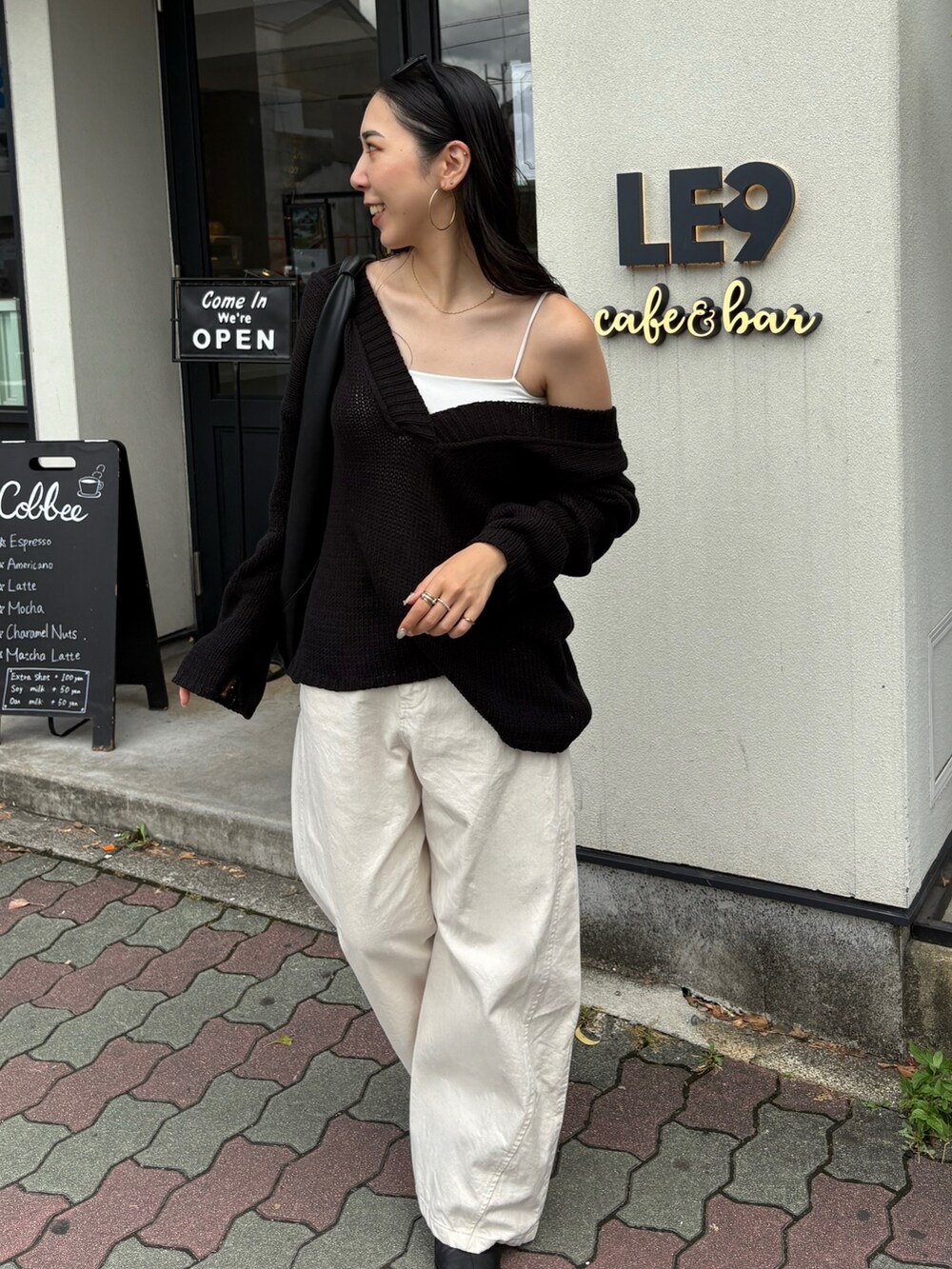 ブラック系のハンドバッグ、ブラック系のブーツを着用したレディースの夏コーディネートの4枚目の写真