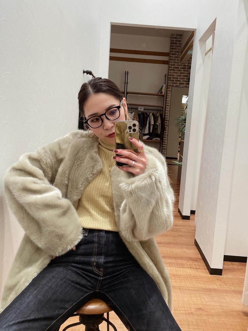 イエロー系のニット/セーター、ブルー系のデニムパンツ、グレー系のその他アウターを着用したレディースの冬コーディネートの3枚目の写真