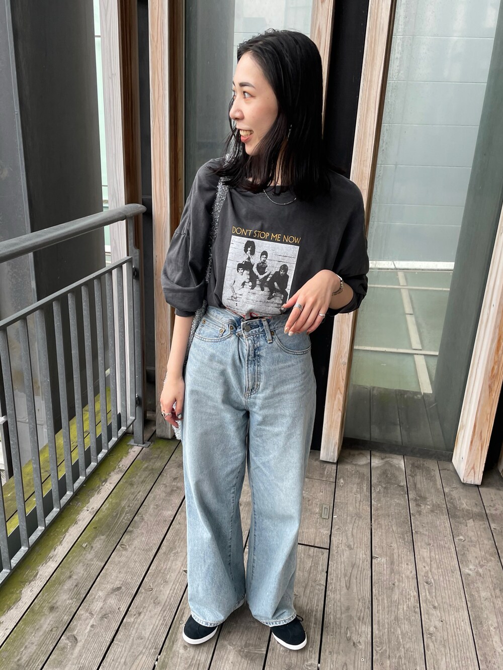 ブラック系のスニーカー、ブルー系のデニムパンツ、グレー系のTシャツ/カットソーを着用したレディースの春コーディネートの3枚目の写真