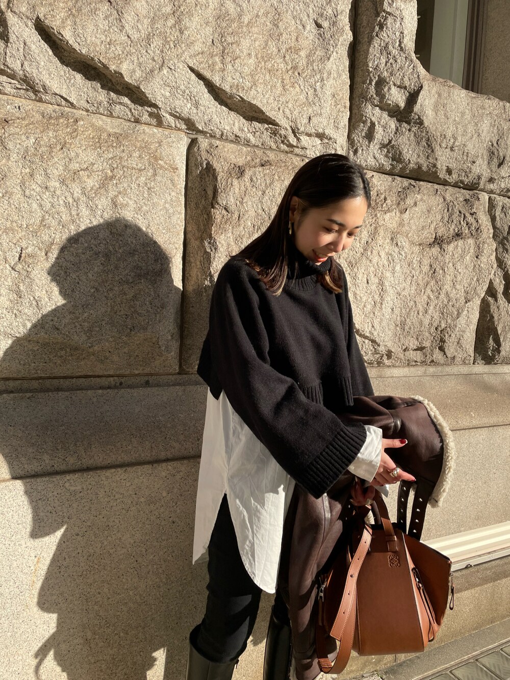 ブラック系のブーツ、ホワイト系のシャツ/ブラウス、ブラック系のニット/セーターを着用したレディースの冬コーディネートの5枚目の写真