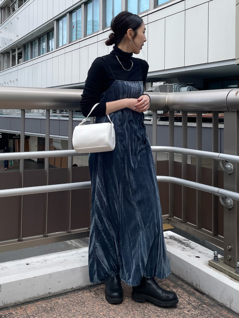 ホワイト系のハンドバッグ、ブルー系のワンピース、ブラック系のニット/セーターを着用したレディースの冬コーディネートの3枚目の写真