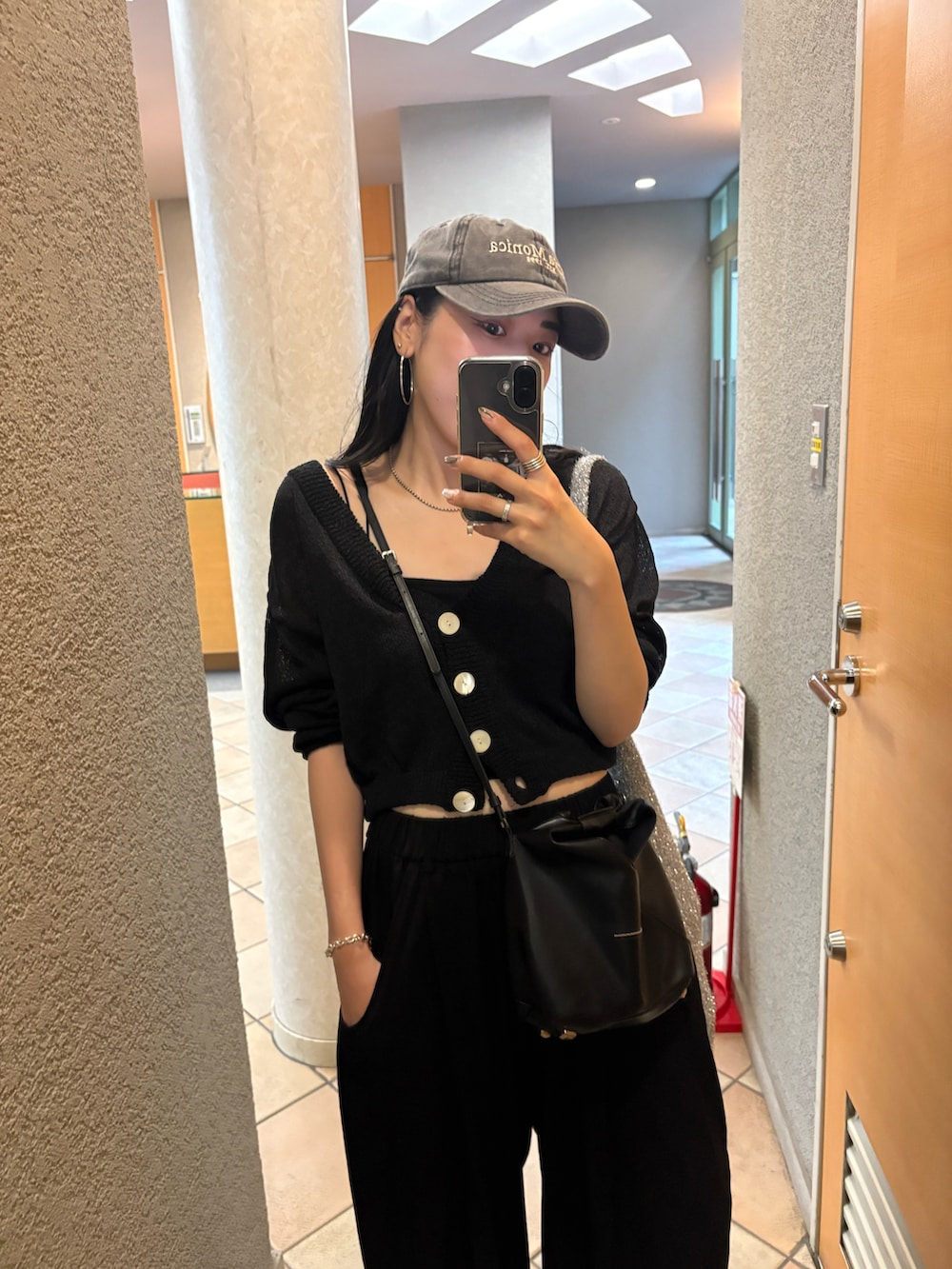 ブラック系のサンダル、ブラック系のショルダーバッグ、シルバー系のトートバッグを着用したレディースの夏コーディネートの5枚目の写真