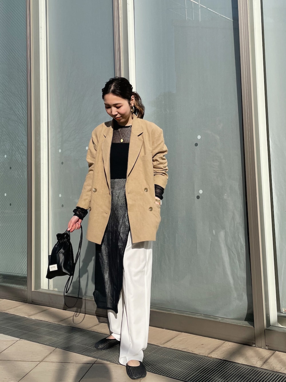 ベージュ系のテーラードジャケット、ブラック系のワンピース、ブラック系のショルダーバッグを着用したレディースの春コーディネートの2枚目の写真