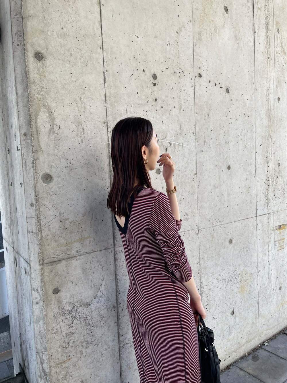 ブラック系のブルゾン、レッド系のワンピース、ブラック系のショルダーバッグを着用したレディースの夏コーディネートの3枚目の写真