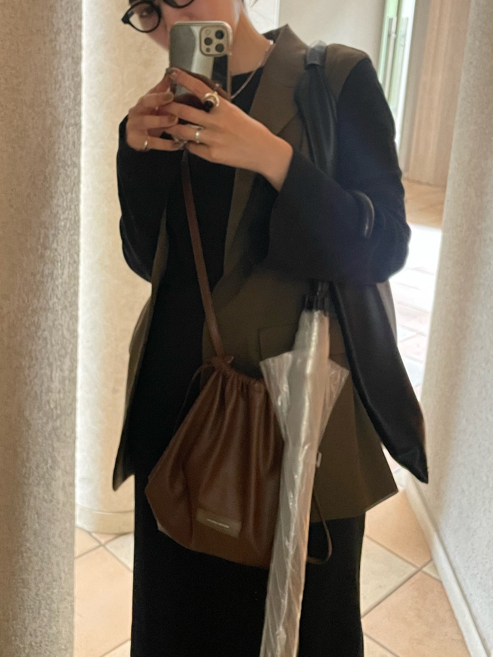 ブラック系のワンピース、ブラウン系のショルダーバッグ、グリーン系のジャケット/アウターを着用したレディースの秋コーディネートの3枚目の写真