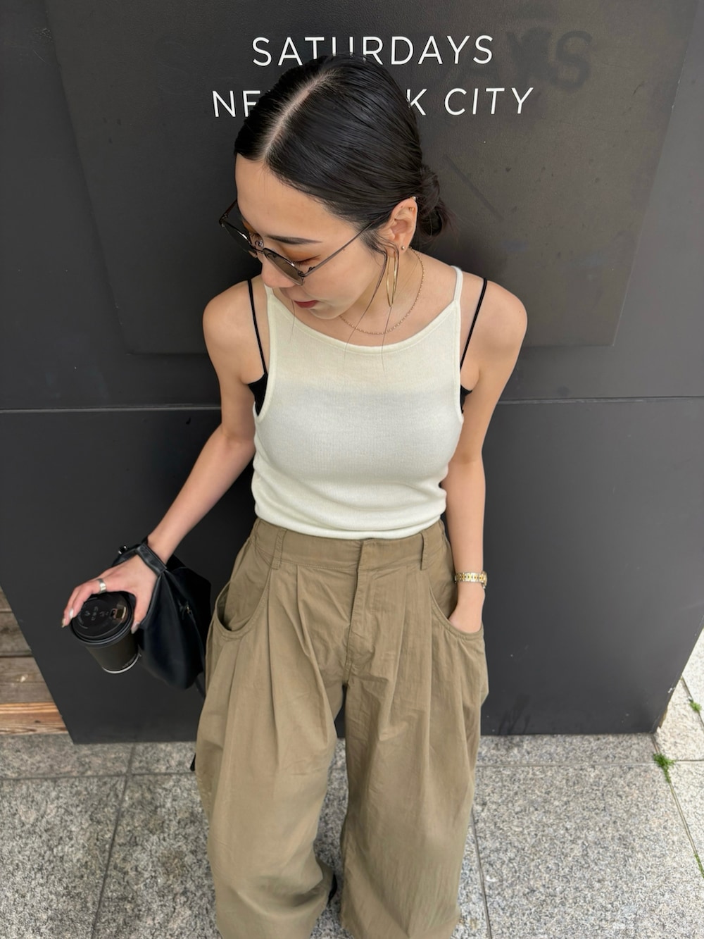 ブラック系のショルダーバッグ、ブラック系のサンダル、シルバー系のピアス（両耳用）を着用したレディースの春コーディネートの5枚目の写真