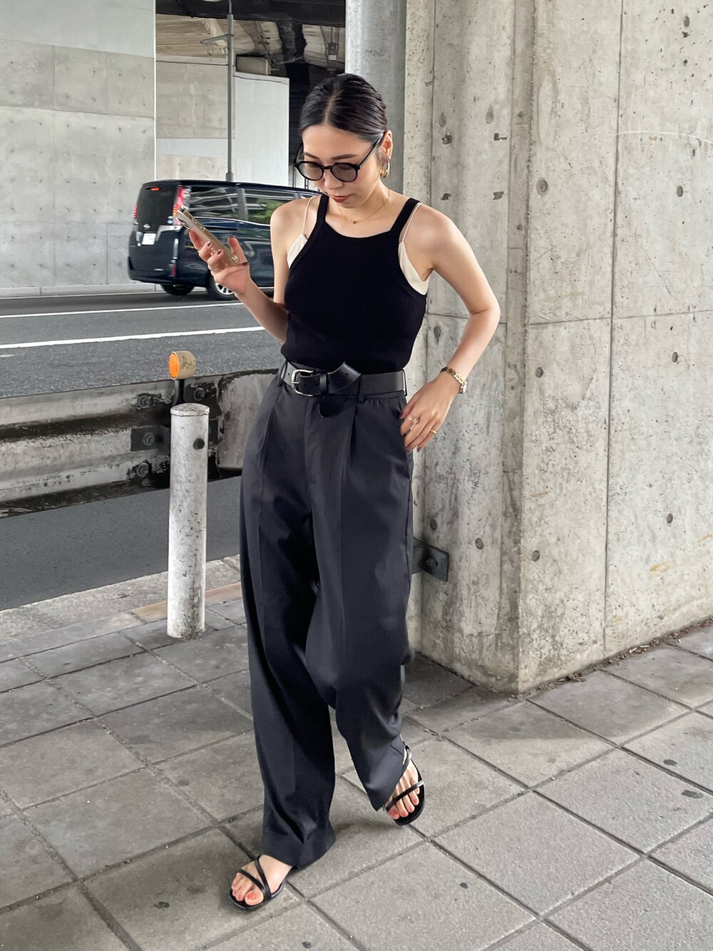 グレー系のスラックス、ブラック系のタンクトップ、ブラック系のベルトを着用したレディースの夏コーディネートの3枚目の写真