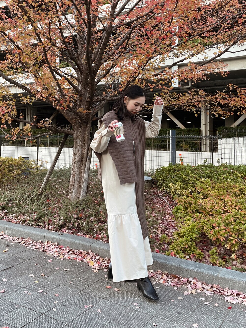 ブラウン系のニット/セーター、ベージュ系のワンピースを着用したレディースの冬コーディネートの2枚目の写真