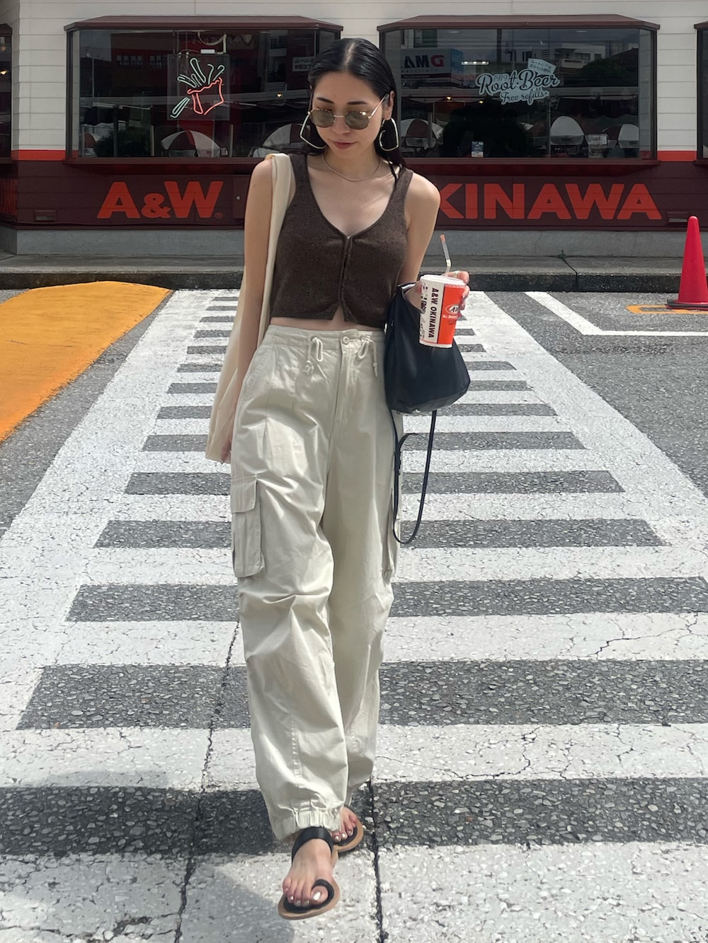 ホワイト系のカーゴパンツ、ブラック系のサンダル、ブラック系のショルダーバッグを着用したレディースの秋コーディネートの2枚目の写真