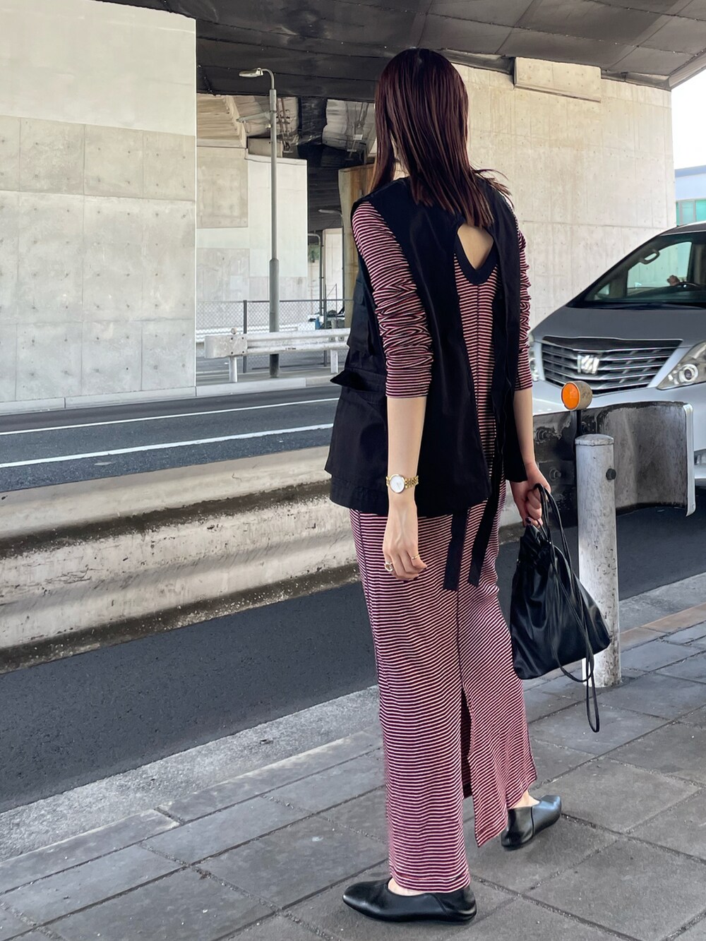 ブラック系のブルゾン、レッド系のワンピース、ブラック系のショルダーバッグを着用したレディースの夏コーディネートの2枚目の写真