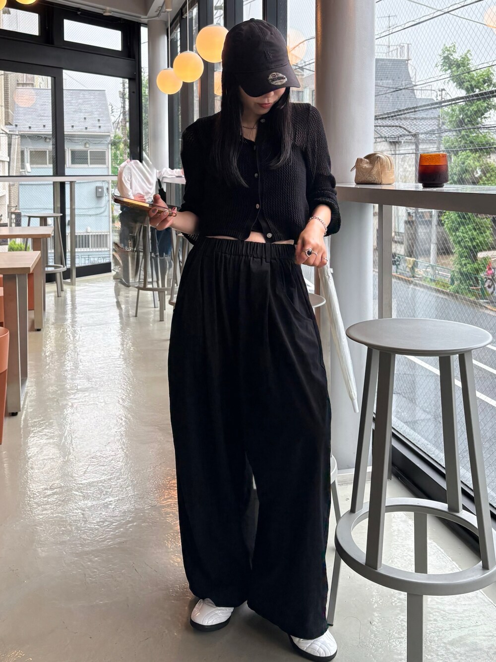 ホワイト系のスニーカー、ブラック系のカーディガン/ボレロ、ブラック系のキャップを着用したレディースの夏コーディネートの2枚目の写真