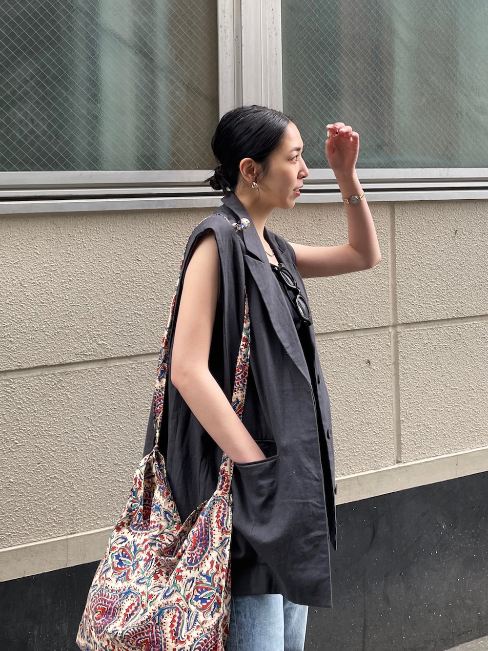 ブルー系のデニムパンツ、ゴールド系のサンダル、ホワイト系のショルダーバッグを着用したレディースの春コーディネートの4枚目の写真