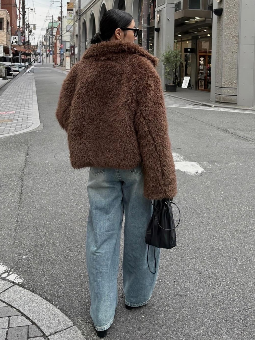 ブラック系のブーツ、ブラック系のショルダーバッグを着用したレディースの秋コーディネートの5枚目の写真