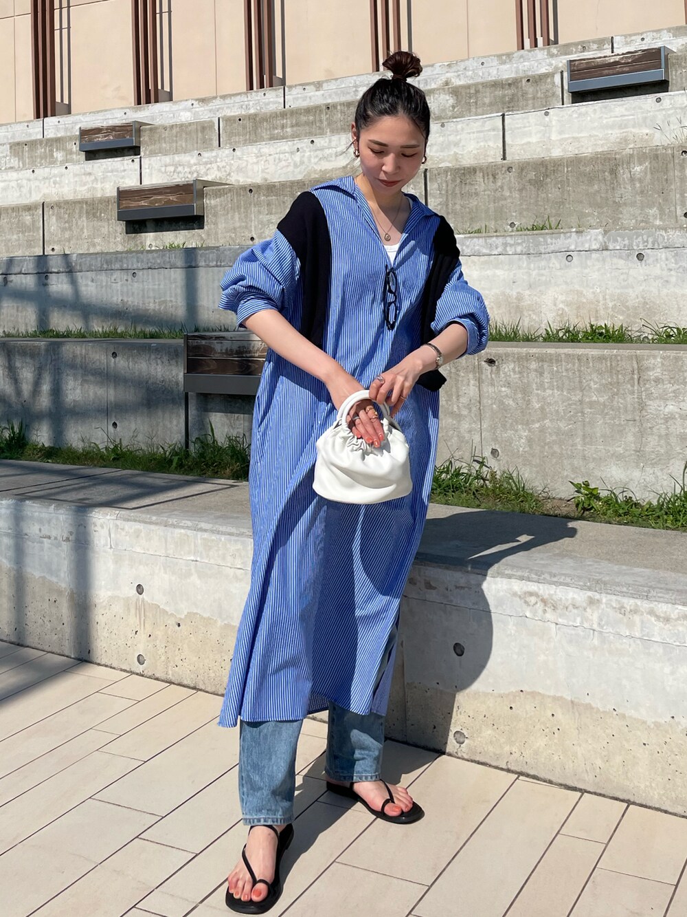 ブルー系のワンピース、ホワイト系のハンドバッグ、ブラック系のサンダルを着用したレディースの夏コーディネートの4枚目の写真