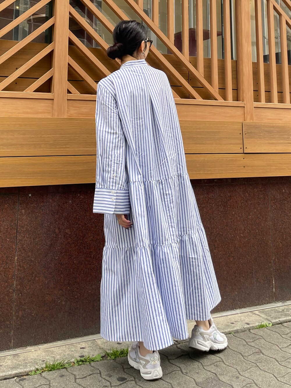 ブラック系のハンドバッグ、ホワイト系のスニーカー、その他のワンピースを着用したレディースの春コーディネートの3枚目の写真