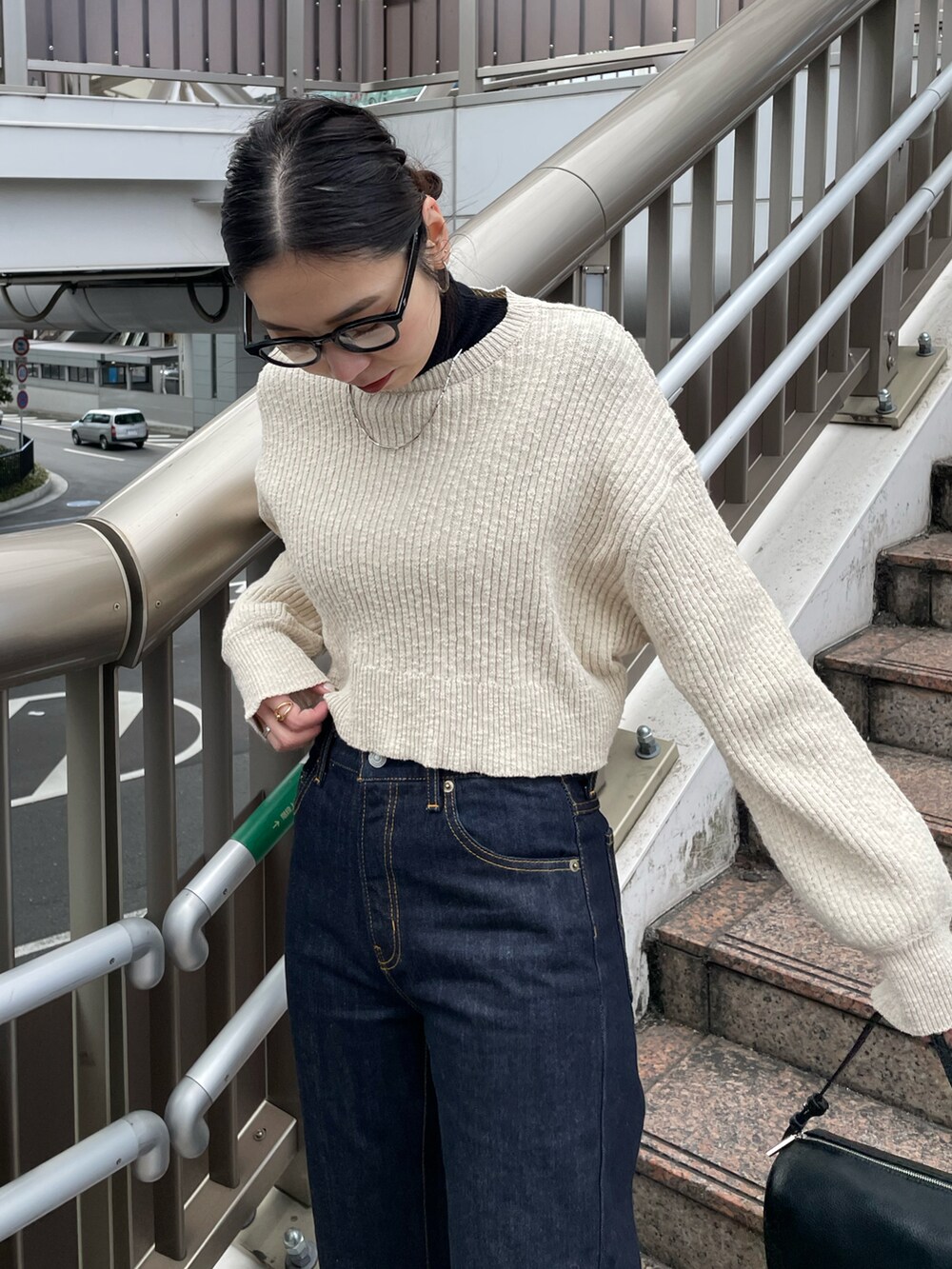 ブルー系のデニムパンツ、ブラック系のワンピースを着用したレディースの冬コーディネートの4枚目の写真