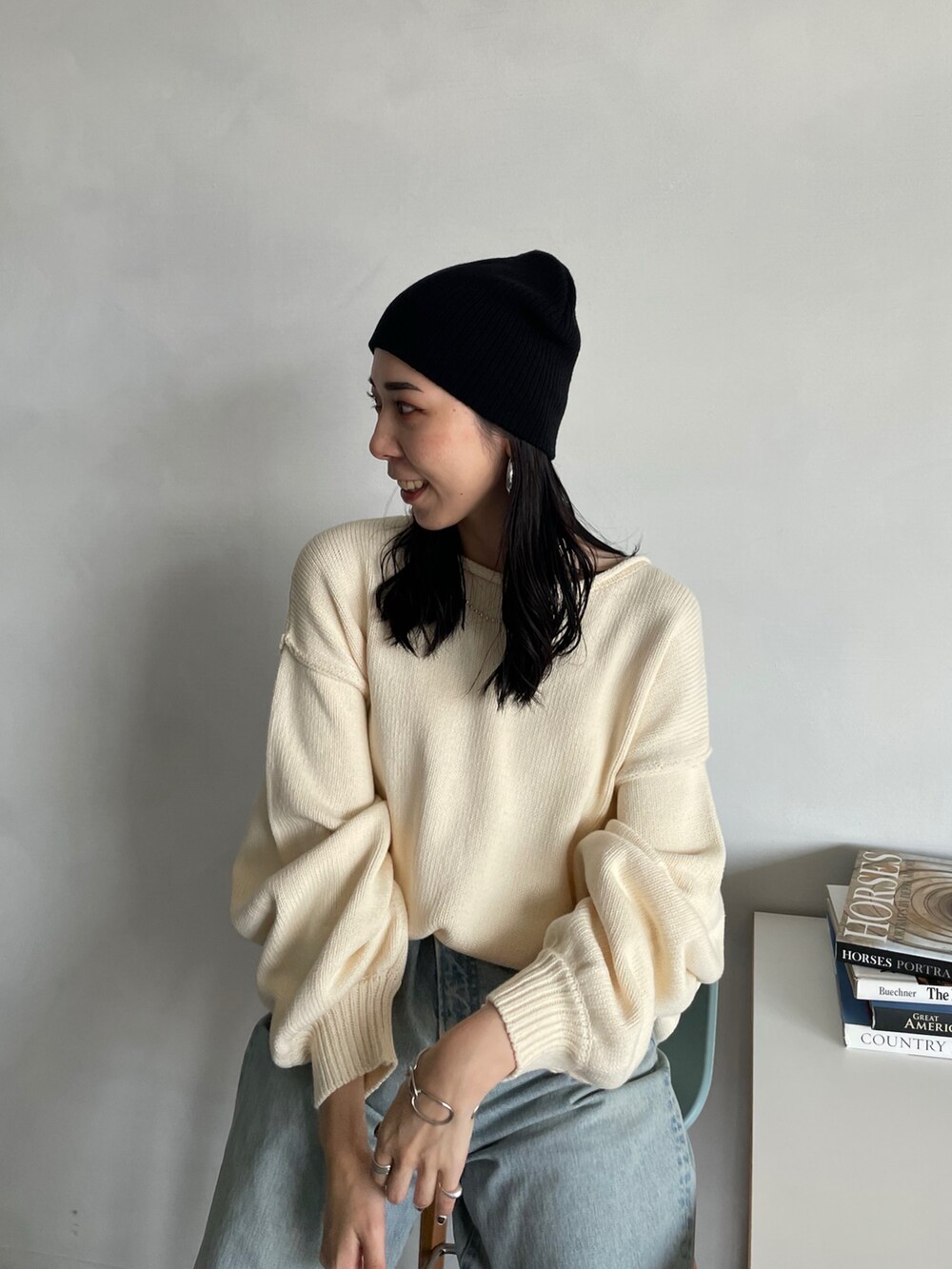 ホワイト系のニット/セーター、ブルー系のデニムパンツ、ブラック系のニットキャップ/ビーニーを着用したレディースの秋コーディネートの3枚目の写真