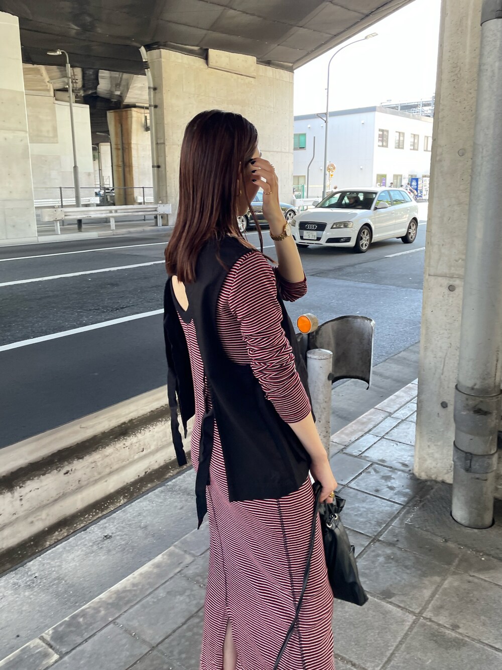 ブラック系のブルゾン、レッド系のワンピース、ブラック系のショルダーバッグを着用したレディースの夏コーディネートの5枚目の写真