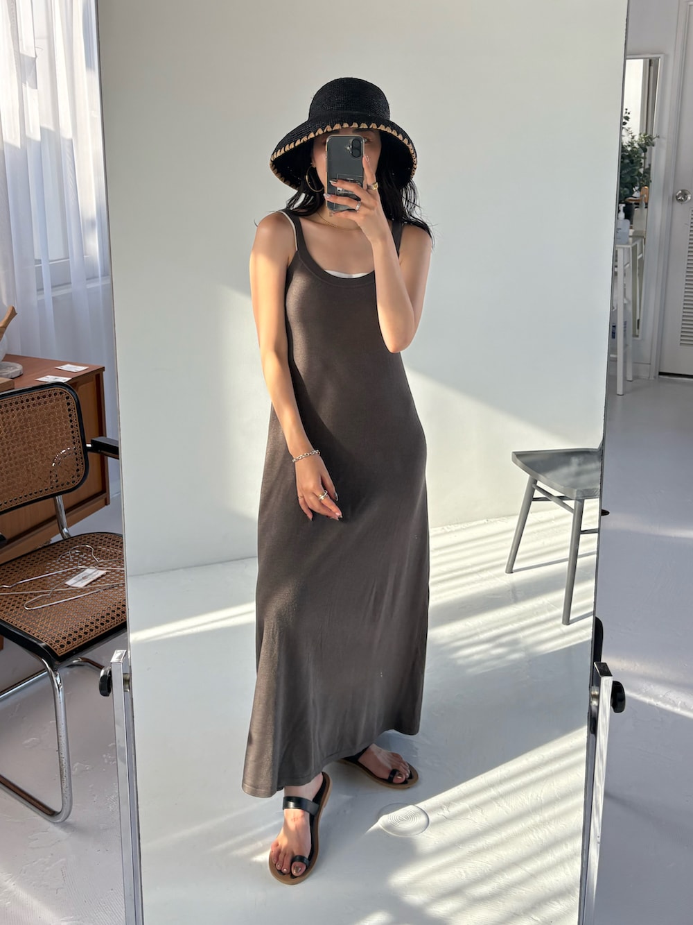 ブラック系のサンダル、ブラック系のハットを着用したレディースの夏コーディネートの2枚目の写真