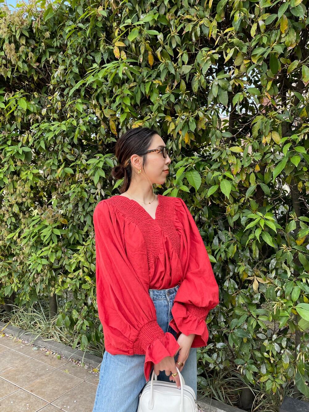 レッド系のシャツ/ブラウス、ブルー系のデニムパンツ、ホワイト系のパンプスを着用したレディースの春コーディネートの5枚目の写真