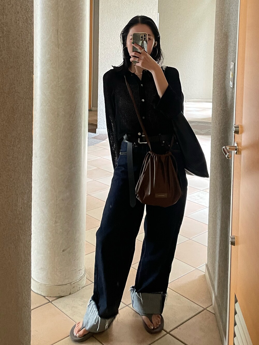 グレー系のサンダル、ブルー系のデニムパンツ、ブラック系のカーディガン/ボレロを着用したレディースの夏コーディネートの3枚目の写真