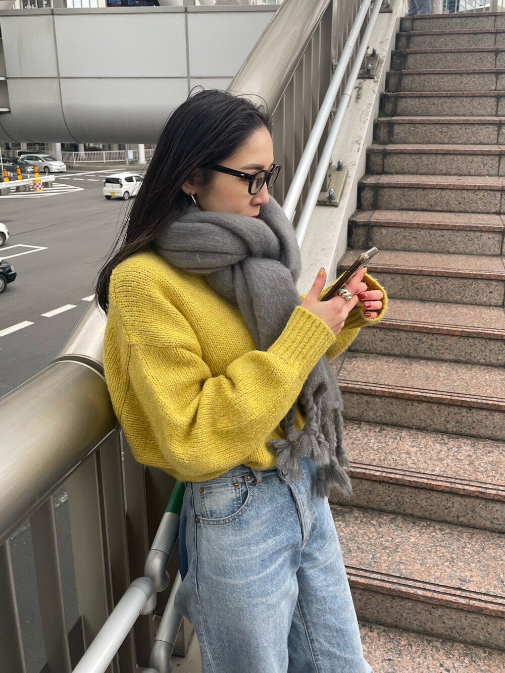 ブルー系のデニムパンツ、ブラック系のブーツ、イエロー系のニット/セーターを着用したレディースの冬コーディネートの5枚目の写真