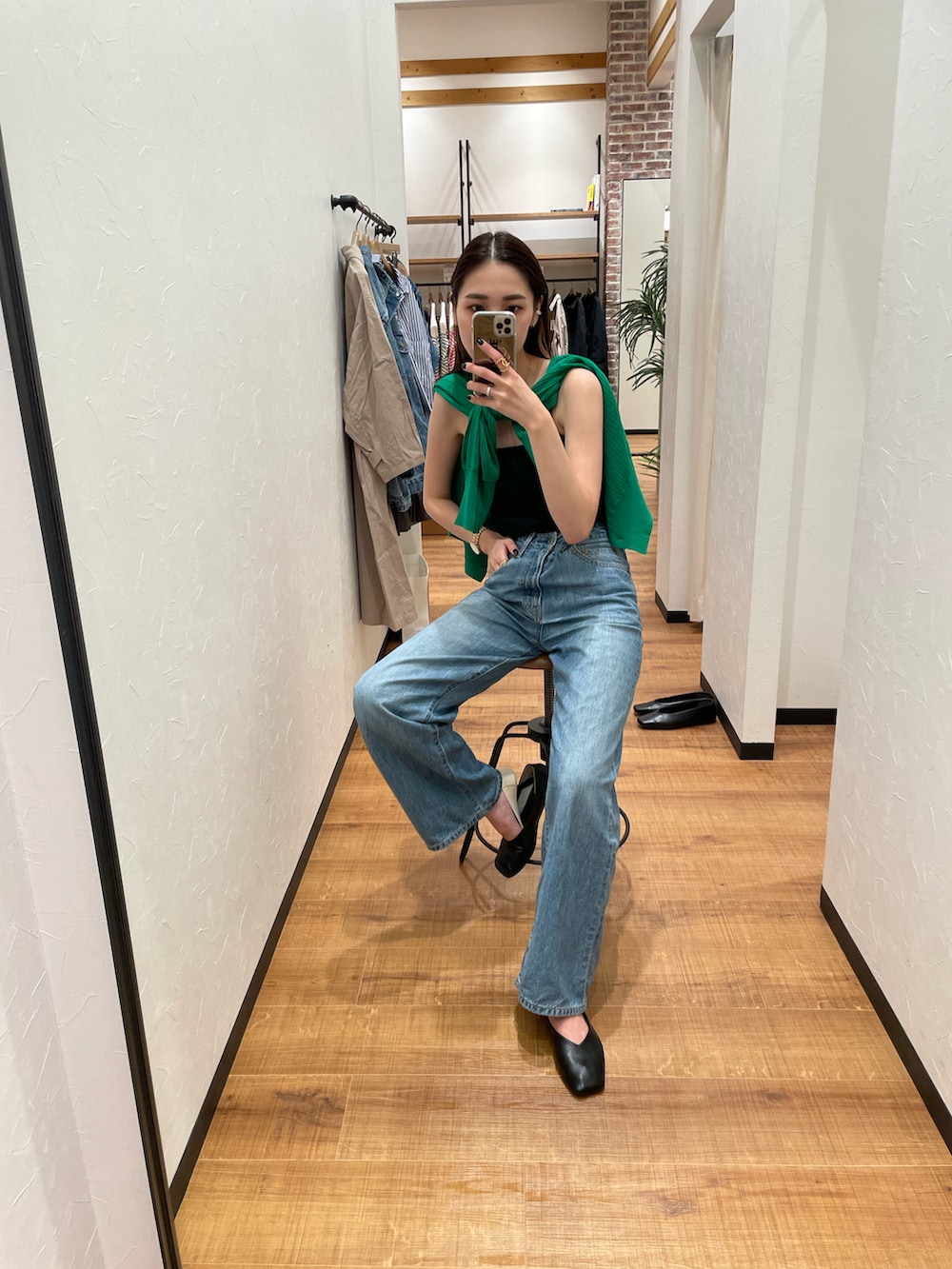 ブラック系のキャミソール、グリーン系のカーディガン/ボレロ、ブルー系のデニムパンツを着用したレディースの夏コーディネートの2枚目の写真