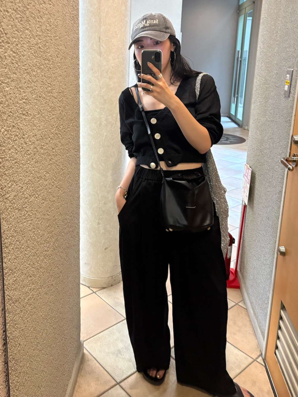 ブラック系のサンダル、ブラック系のショルダーバッグ、シルバー系のトートバッグを着用したレディースの夏コーディネートの4枚目の写真