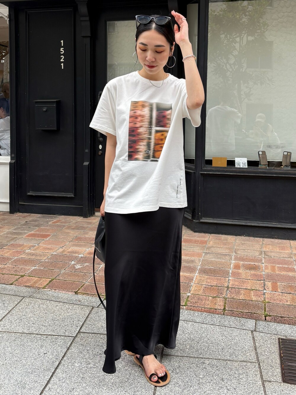 ブラック系のサンダル、ブラック系のショルダーバッグ、シルバー系のネックレスを着用したレディースの夏コーディネートの4枚目の写真