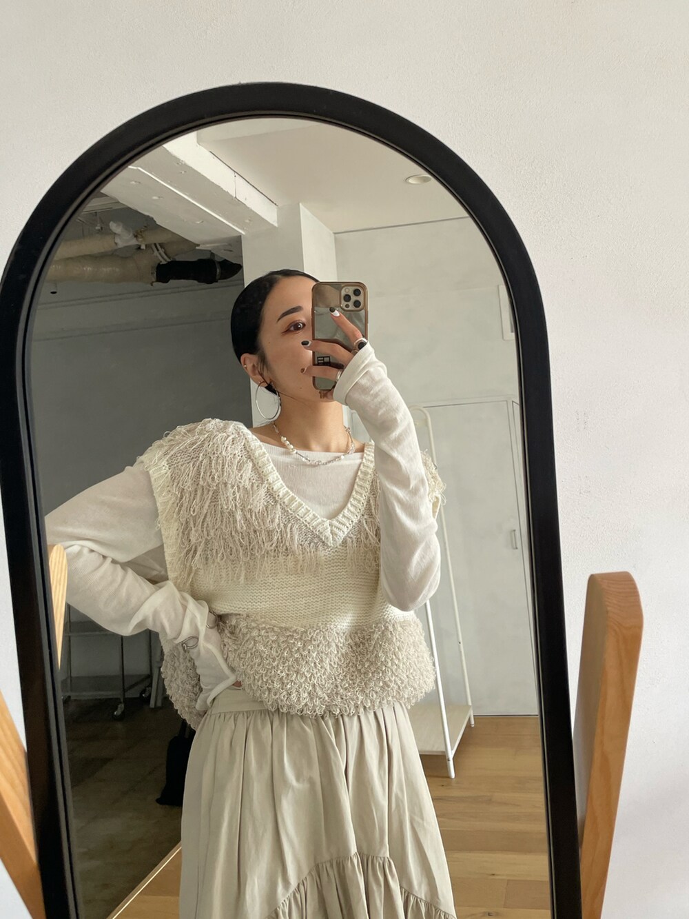 ホワイト系のスカート、ホワイト系のベスト、ホワイト系のTシャツ/カットソーを着用したレディースの春コーディネートの2枚目の写真