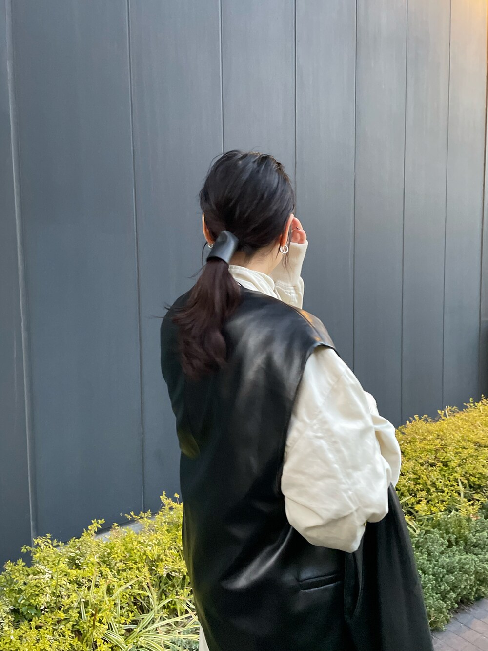 ブラック系のジャケット/アウター、ホワイト系のその他アウター、ブラック系のハンドバッグを着用したレディースの春コーディネートの4枚目の写真