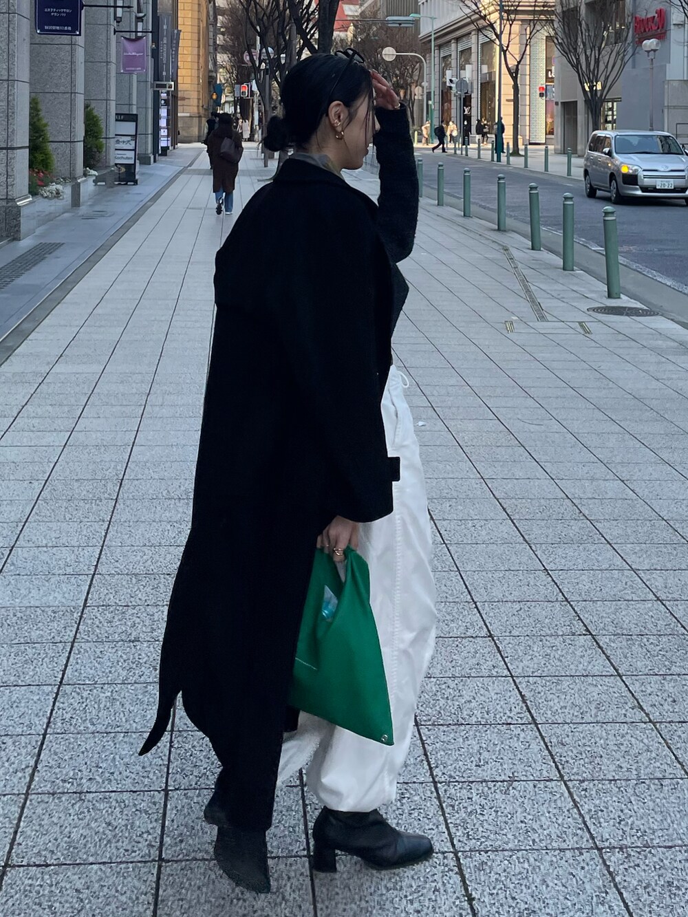 ブルー系のTシャツ/カットソー、グレー系のニット/セーター、グリーン系のショルダーバッグを着用したレディースの春コーディネートの5枚目の写真