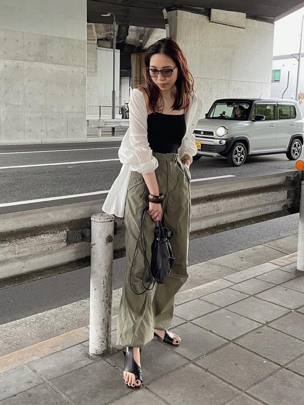 ブラック系のキャミソール、ホワイト系のシャツ/ブラウス、ブラック系のショルダーバッグを着用したレディースの春コーディネートの4枚目の写真