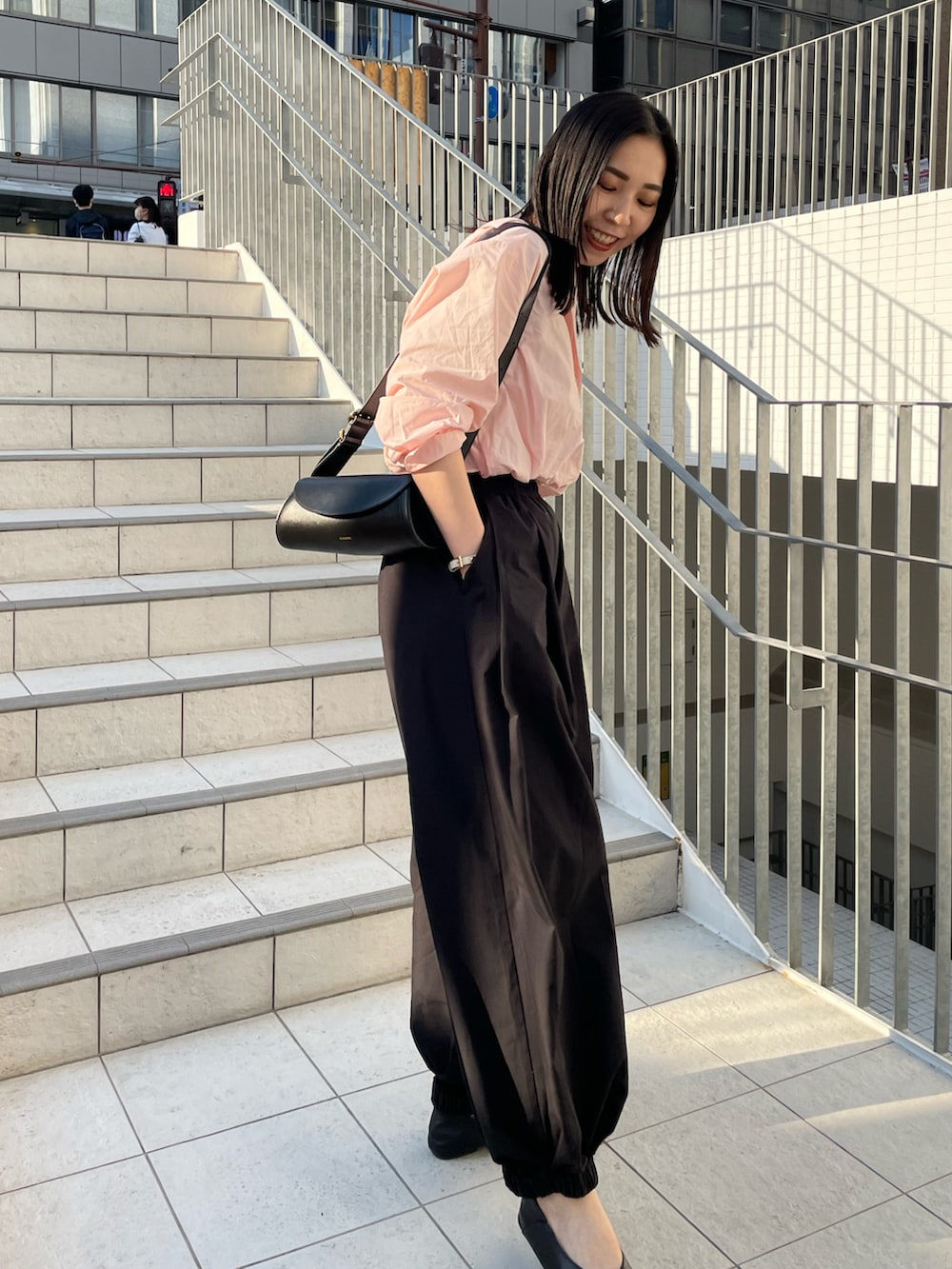 ピンク系のシャツ/ブラウス、ブラック系のその他パンツ、ブラック系のショルダーバッグを着用したレディースの春コーディネートの5枚目の写真