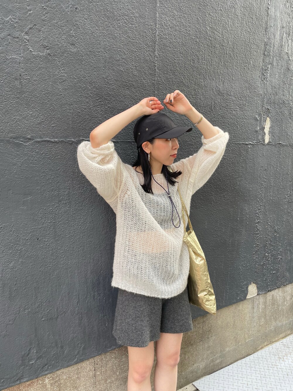 ブラック系のスニーカー、ホワイト系のニット/セーター、グレー系のその他パンツを着用したレディースの秋コーディネートの4枚目の写真