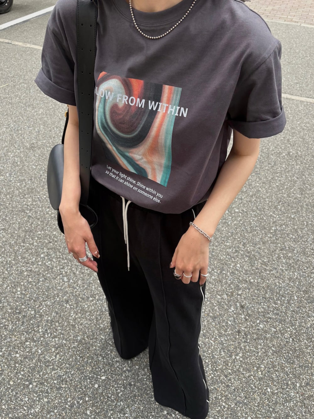 ホワイト系のスニーカー、ブラック系のショルダーバッグ、ブラック系のその他パンツを着用したレディースの夏コーディネートの3枚目の写真