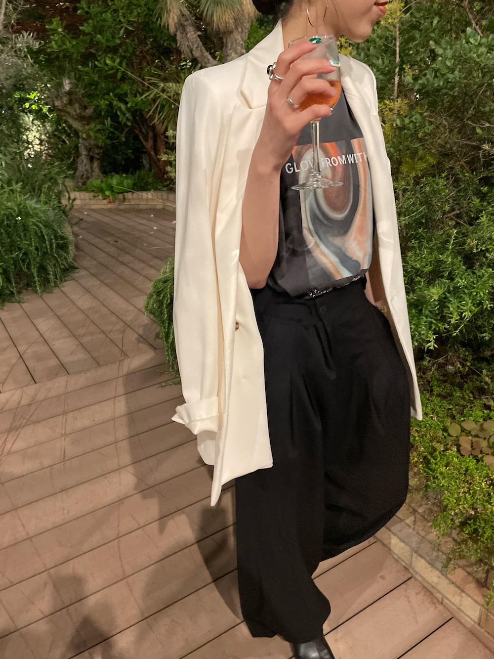 ブラック系のスラックス、ブラック系のサンダル、ホワイト系のテーラードジャケットを着用したレディースの夏コーディネートの5枚目の写真