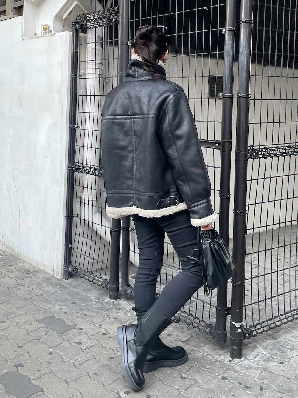 ブラック系のショルダーバッグ、ブラック系のデニムパンツ、シルバー系のニット/セーターを着用したレディースの秋コーディネートの4枚目の写真