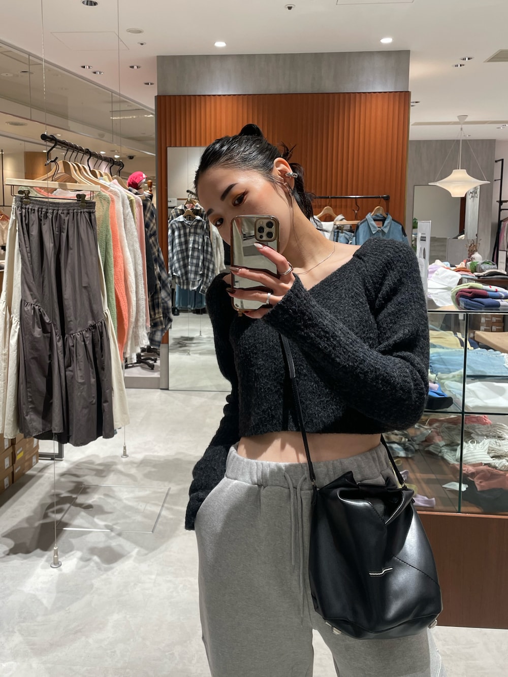 ブラック系のブーツ、グレー系のニット/セーター、ブラック系のショルダーバッグを着用したレディースの秋コーディネートの4枚目の写真