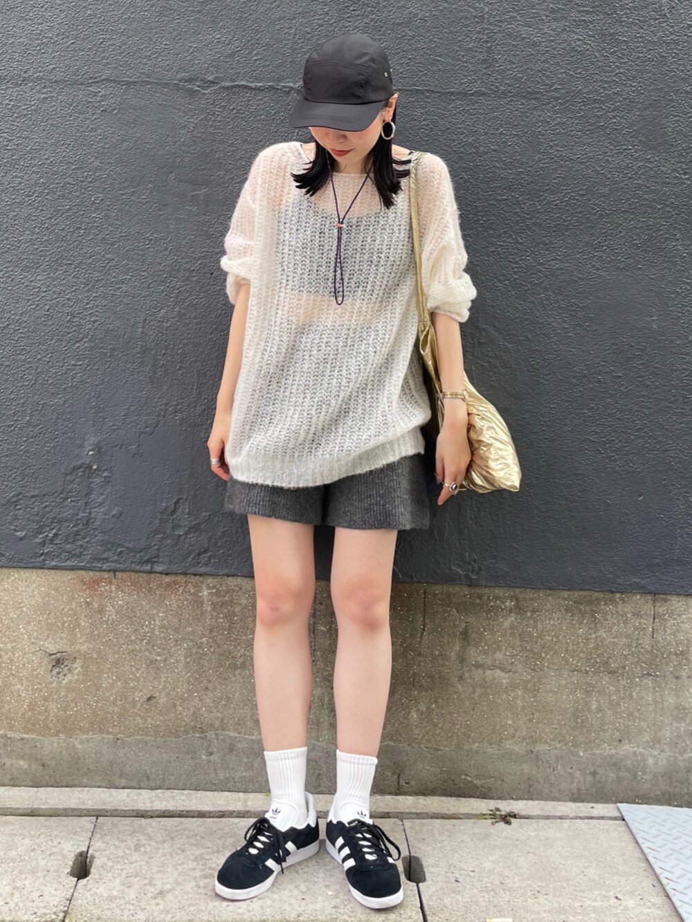 ブラック系のスニーカー、ホワイト系のニット/セーター、グレー系のその他パンツを着用したレディースの秋コーディネートの2枚目の写真