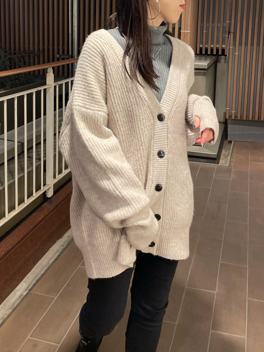 ホワイト系のカーディガン/ボレロ、ブラック系のデニムパンツ、ブラック系のブーツを着用したレディースの冬コーディネートの5枚目の写真